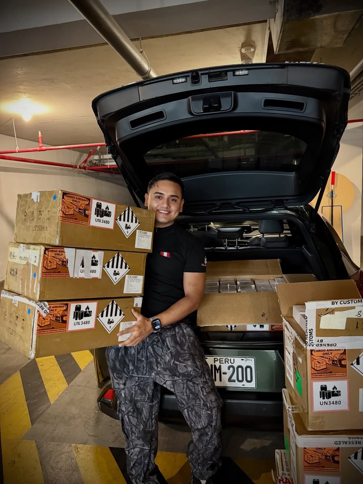 Eduardo Zarzosa cargando cajas de stock importado en la maletera de su auto en Lima